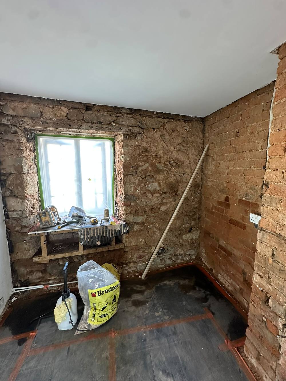 Old cob and stone walls hacked off back to bare stone in a Devon cottage
