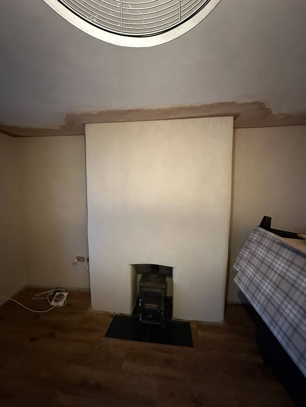 Lime plastered chimney breast finished around a log burner