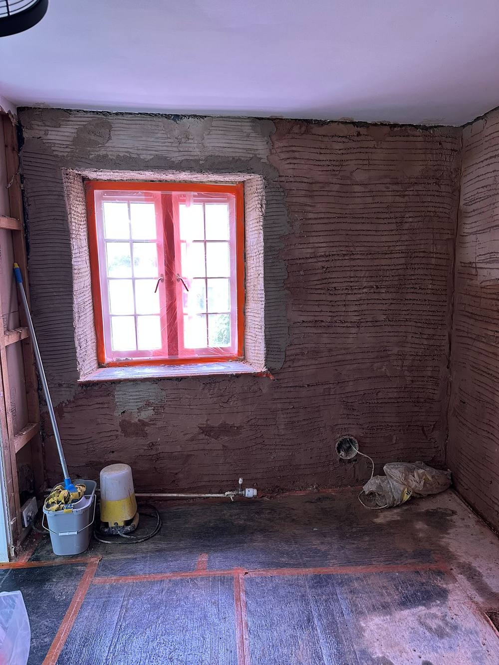 Lime scratch coat combed around a cottage window ready for the next coat