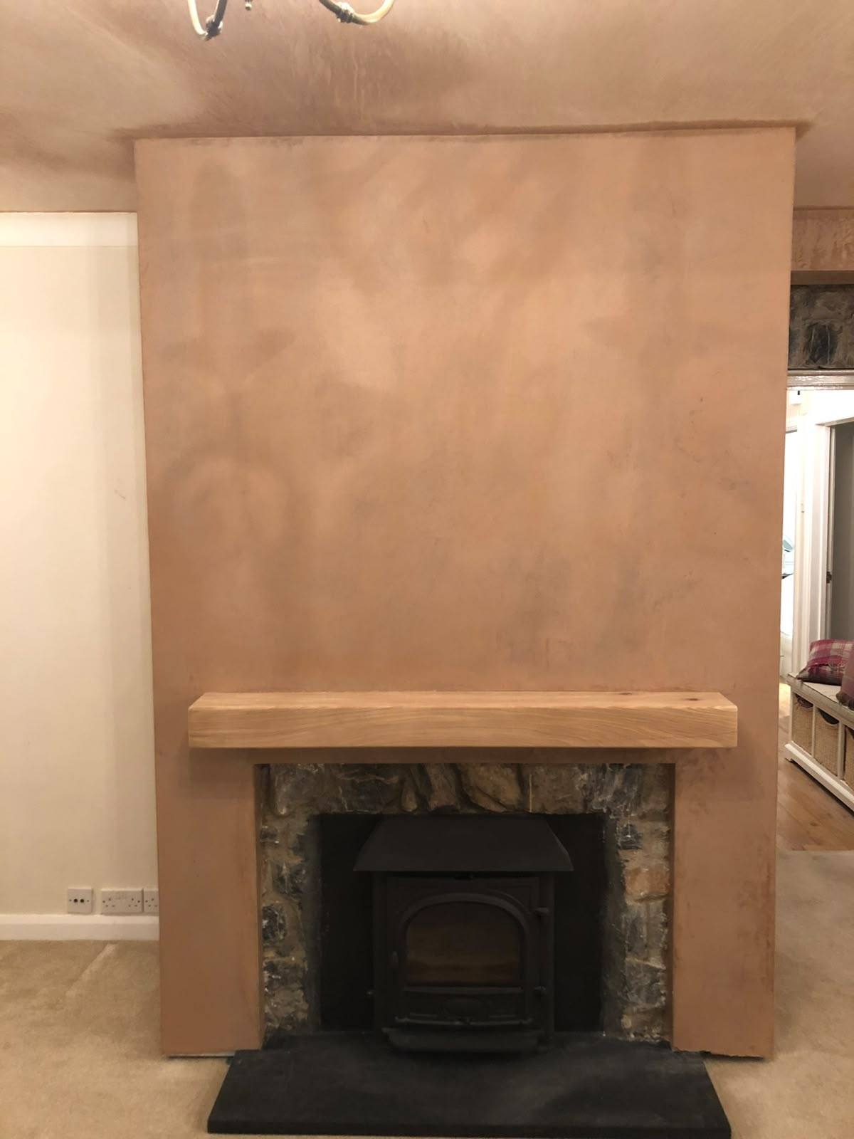 Chimney breast skimmed around a log burner with oak beam mantel